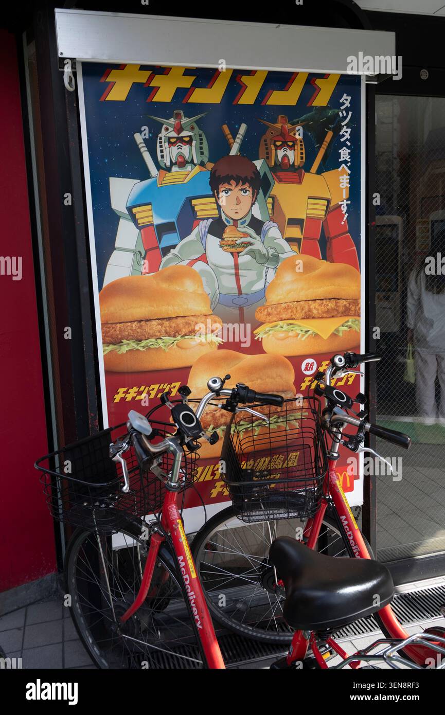 Japan April 2026 Tokio. Außerhalb von McDonalds - futuristisches Werbeplakat und Lieferräder Stockfoto