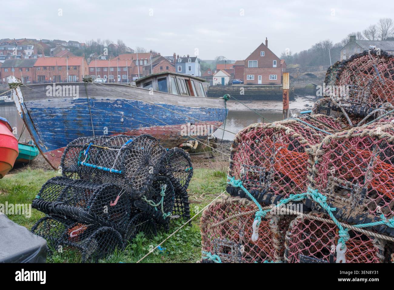 Hummertöpfe neben einem verfallenen Fischerboot in Whitby, North Yorkshire Stockfoto