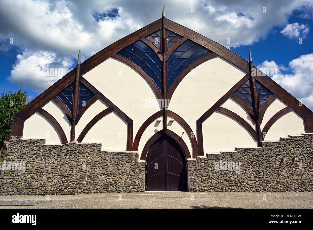 Ein detailliertes mittelgroßes frontales Bild, das die spektakuläre Fassade der Magyar Laszlo Sporthalle in Visegrád, Ungarn, zeigt. Das Gebäude ist mit einem Anthr Stockfoto