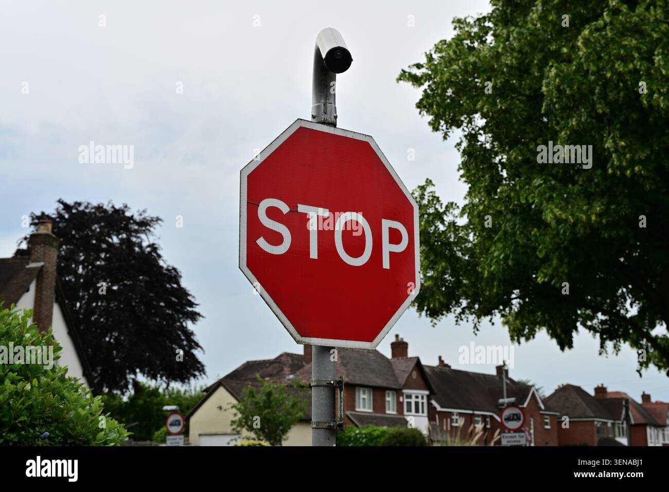 Stoppschild mit Überwachungskamera in ruhiger Vorstadtgegend Stockfoto