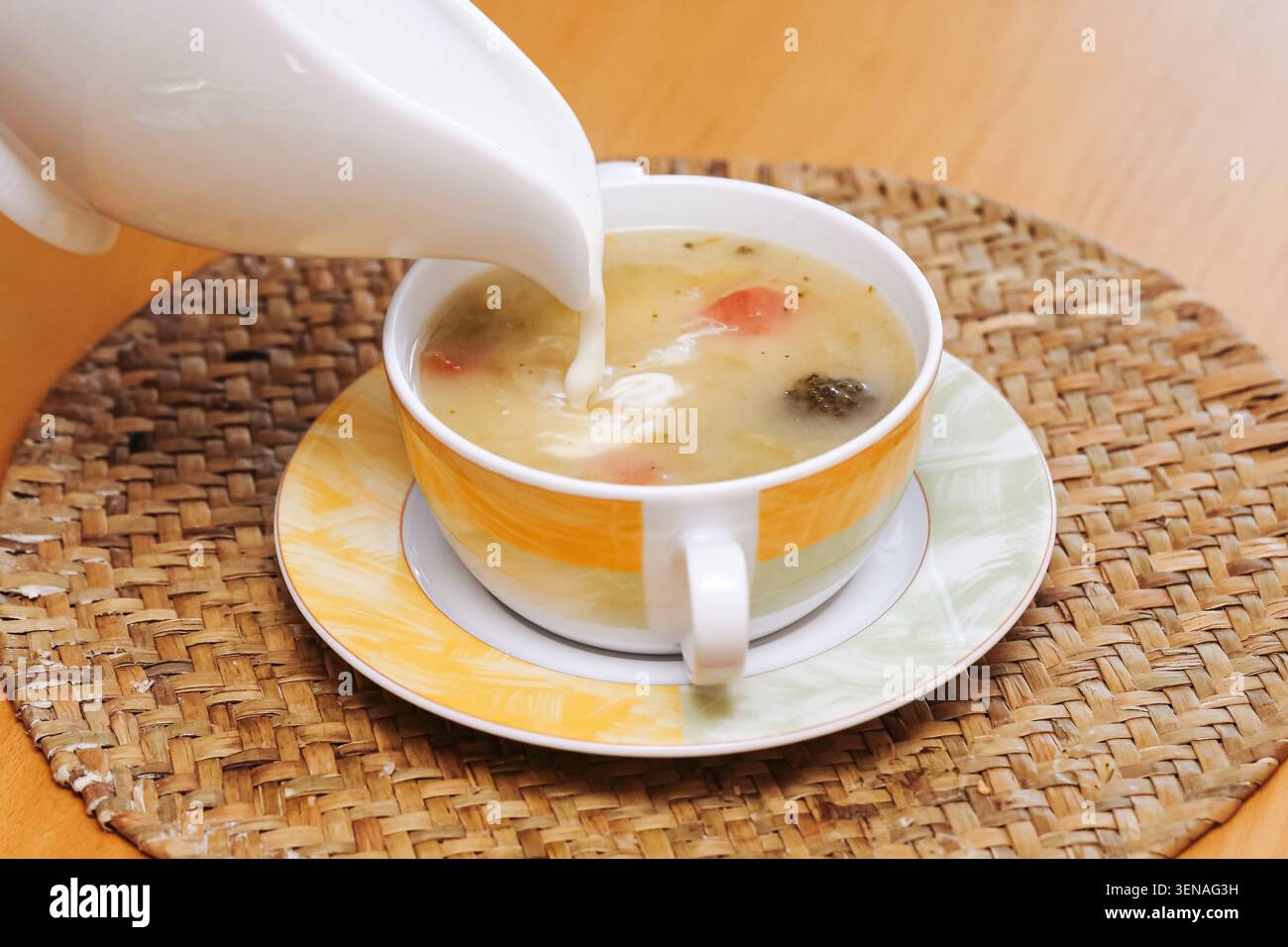 Creme wird in hausgemachte Suppen-Nahaufnahme gegossen. Comfort Food Hintergrund für warme Familienmahlzeiten gesunde Mittagessen und traditionelle Hausmannskost. Stockfoto