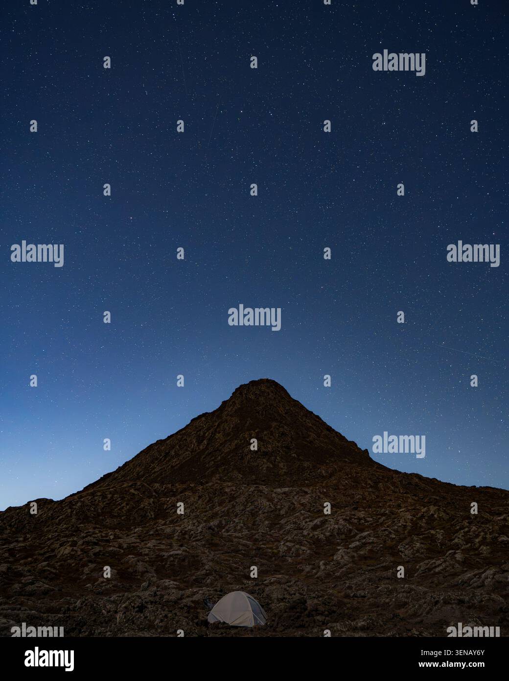 Nächtlicher Blick auf den Piquinho Gipfel mit einem beleuchteten Campingzelt im Vordergrund unter einem Sternenhimmel, Mount Pico, Azoren, Portugal Stockfoto