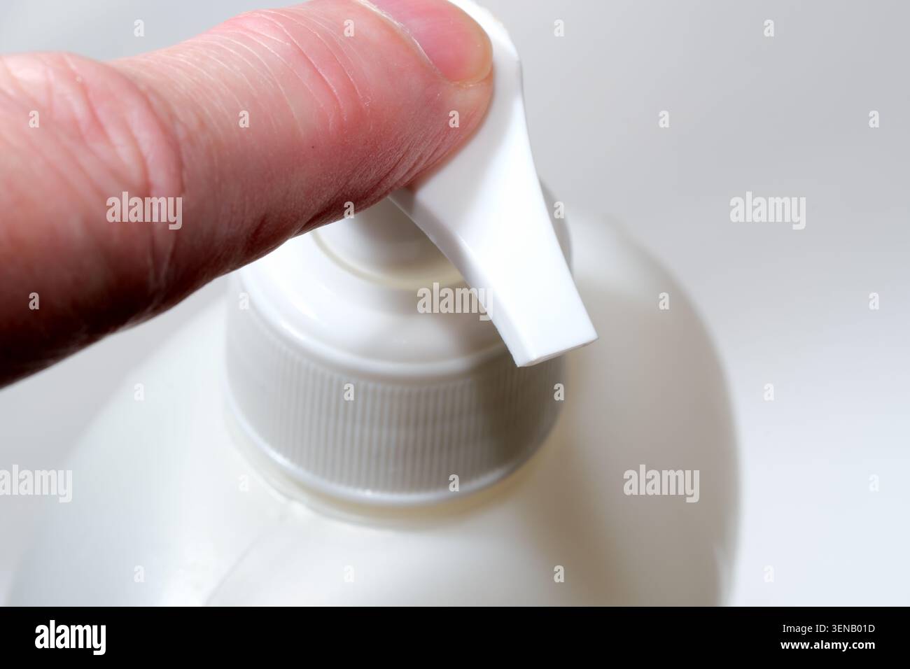 Eine Hand drückt sanft auf die Oberseite der Pumpe, um flüssige Seife mühelos zu verteilen. Stockfoto