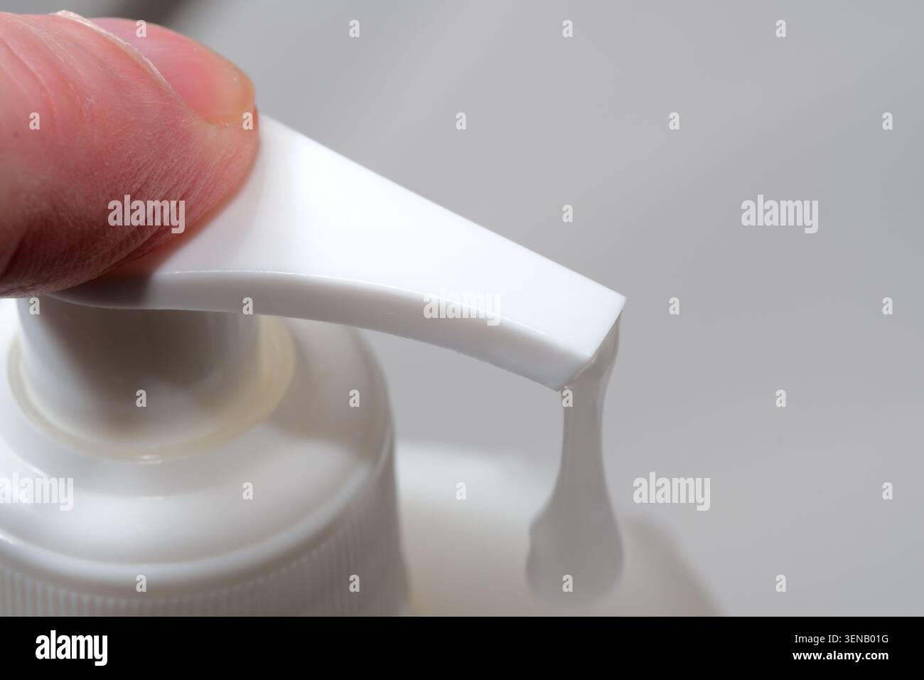 Drücken Sie vorsichtig eine Pumpflasche zusammen, um eine glatte Lotion für die Feuchtigkeit der Haut zu geben. Stockfoto
