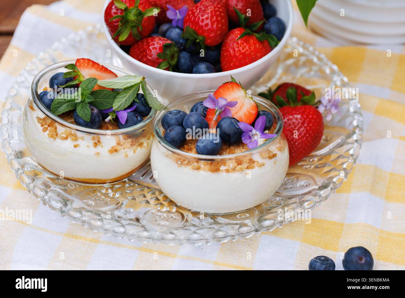 Beeren-Käsekuchen-Dessert mit Erdbeeren und Heidelbeeren in Glasbecher Stockfoto