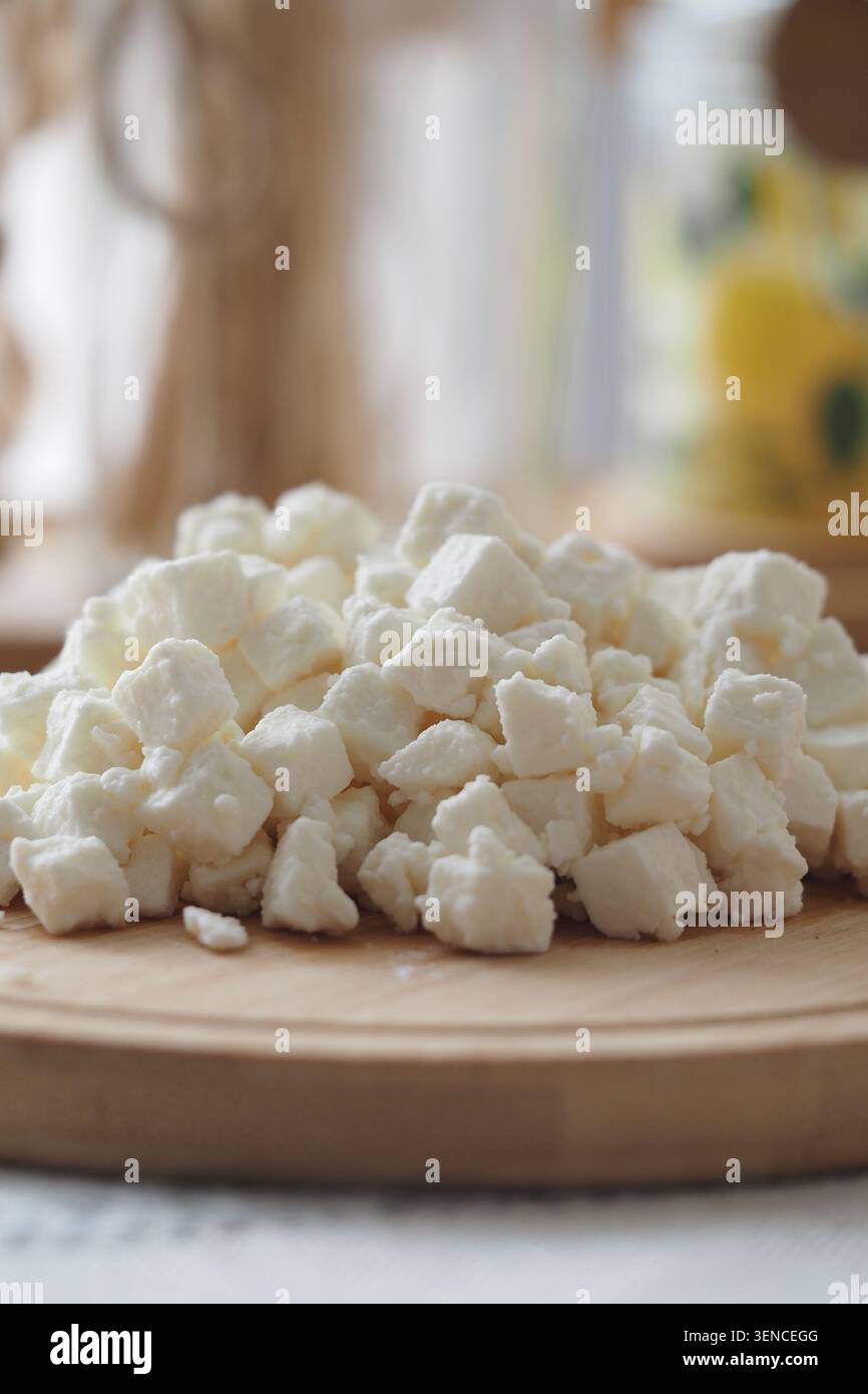 Frische Käsewürfel auf Holzbrett in der Küche Stockfoto