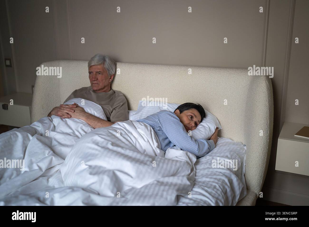 Erschöpfte ältere Menschen heirateten im Bett, mit Frustration und Enttäuschung, nachdem sie sich gestritten hatten. Stockfoto