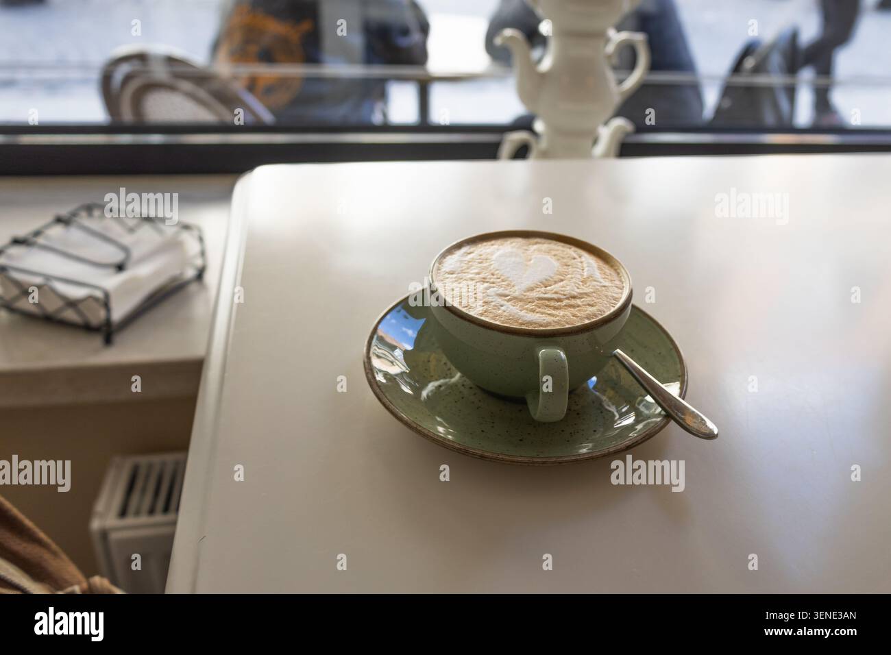 Frischer heißer Latte mit Latte Art in einer grünen Keramikschale Stockfoto