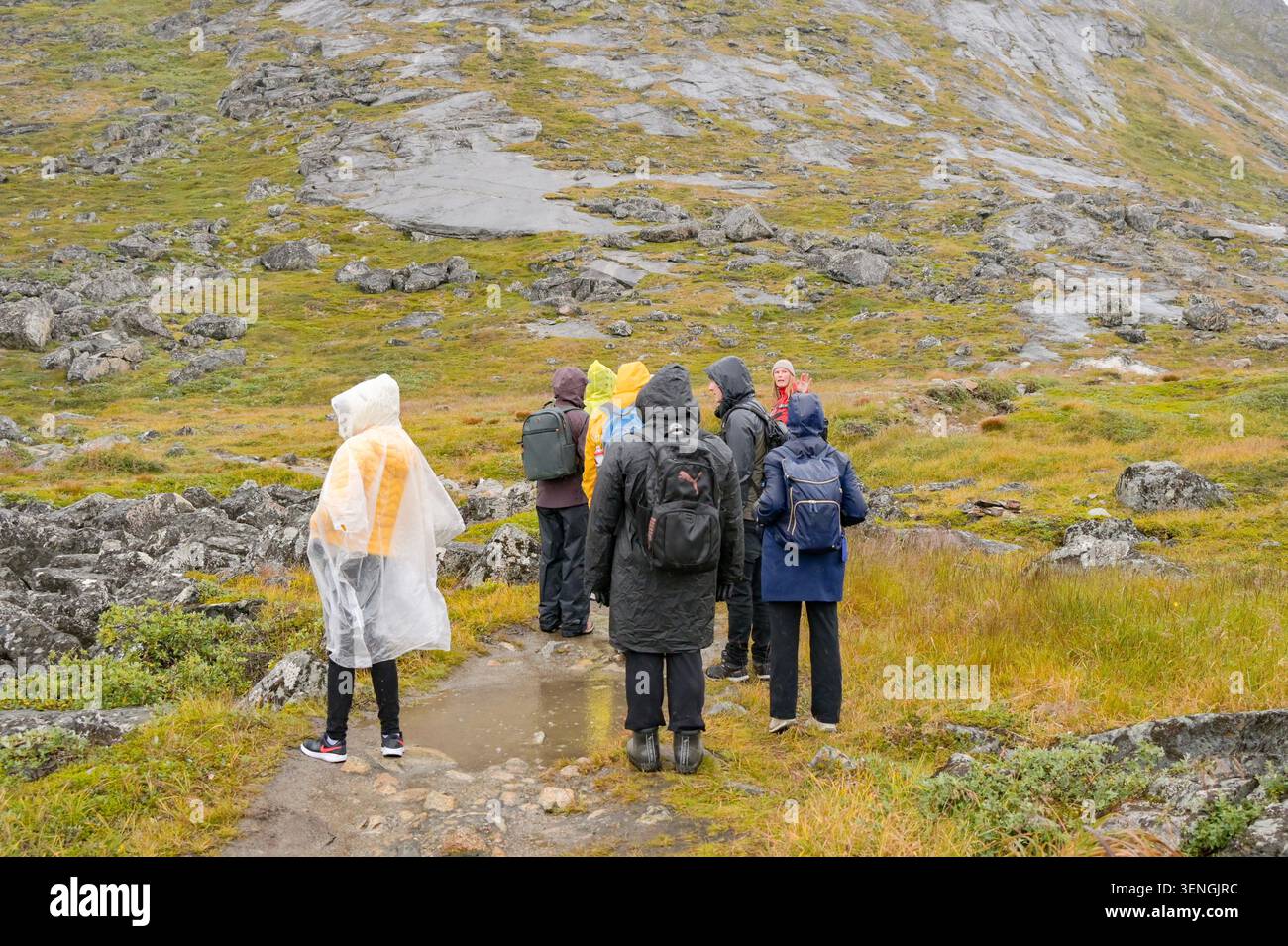 Qaqortoq, Grönland - 28. August 2024: Touristen wandern bei nassem und nebeligem Wetter am Rande des Tasersuaq-Sees in Qaqortoq. Stockfoto