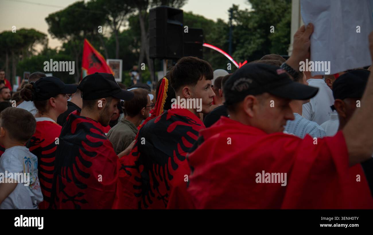 Demonstranten, die Hemden tragen, die mit dem albanischen Doppeladler verziert sind, versammeln sich während einer Demonstration der Opposition unter Nationalflaggen. Stockfoto