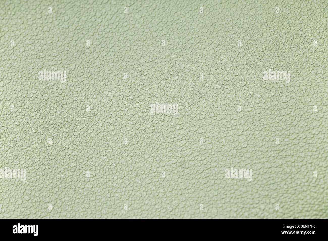 Hellgrüner strukturierter Hintergrund mit dezenten Unebenheiten und unregelmäßigem Muster, abstraktes Designelement für Grafikprojekte Stockfoto