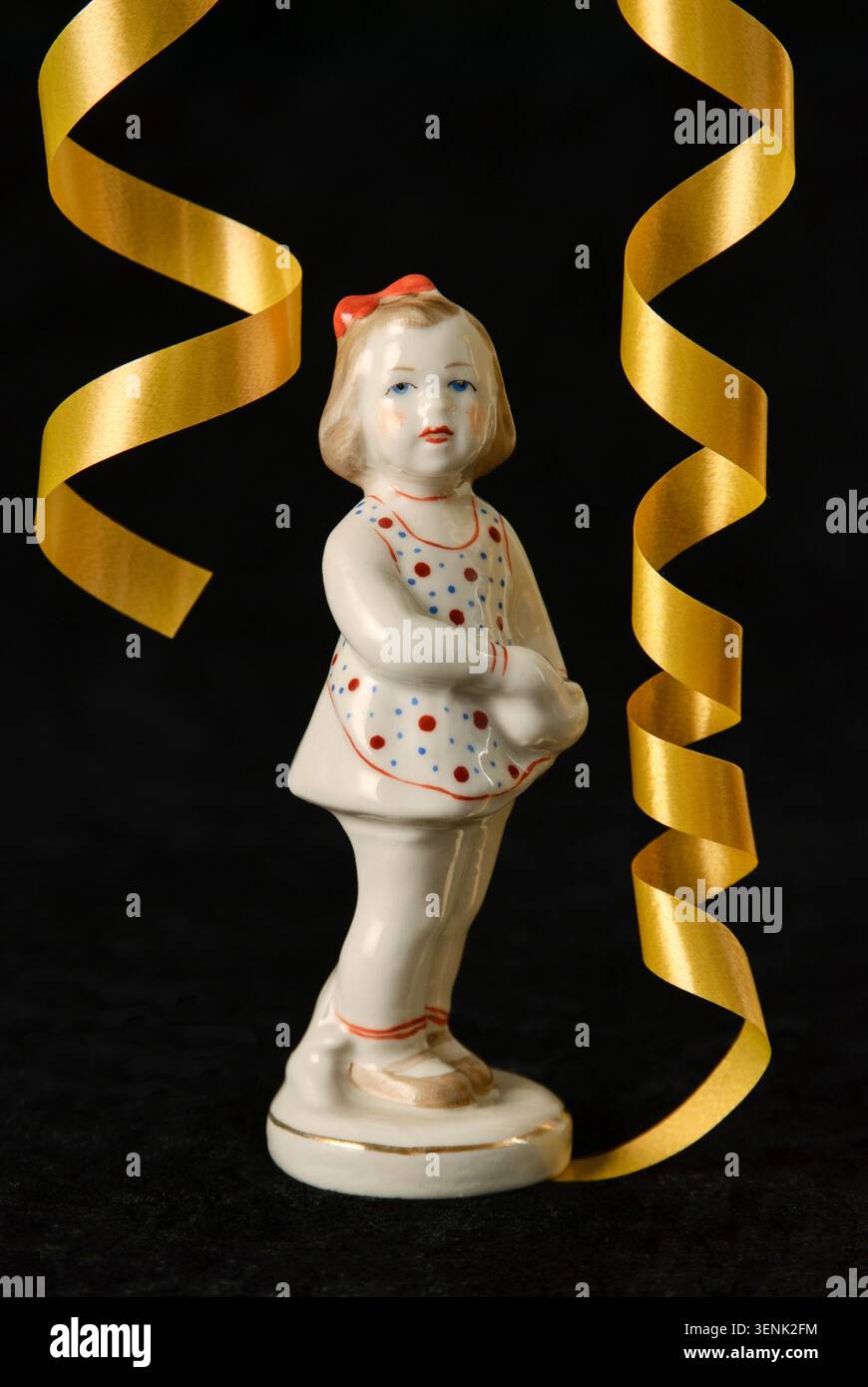 Eine seltene antike Porzellanfigur, „Ja, Mama“, hergestellt in der UdSSR von der Rigaer Porzellanfabrik. Nahaufnahme der Vorderseite mit einem goldenen Festband. Stockfoto