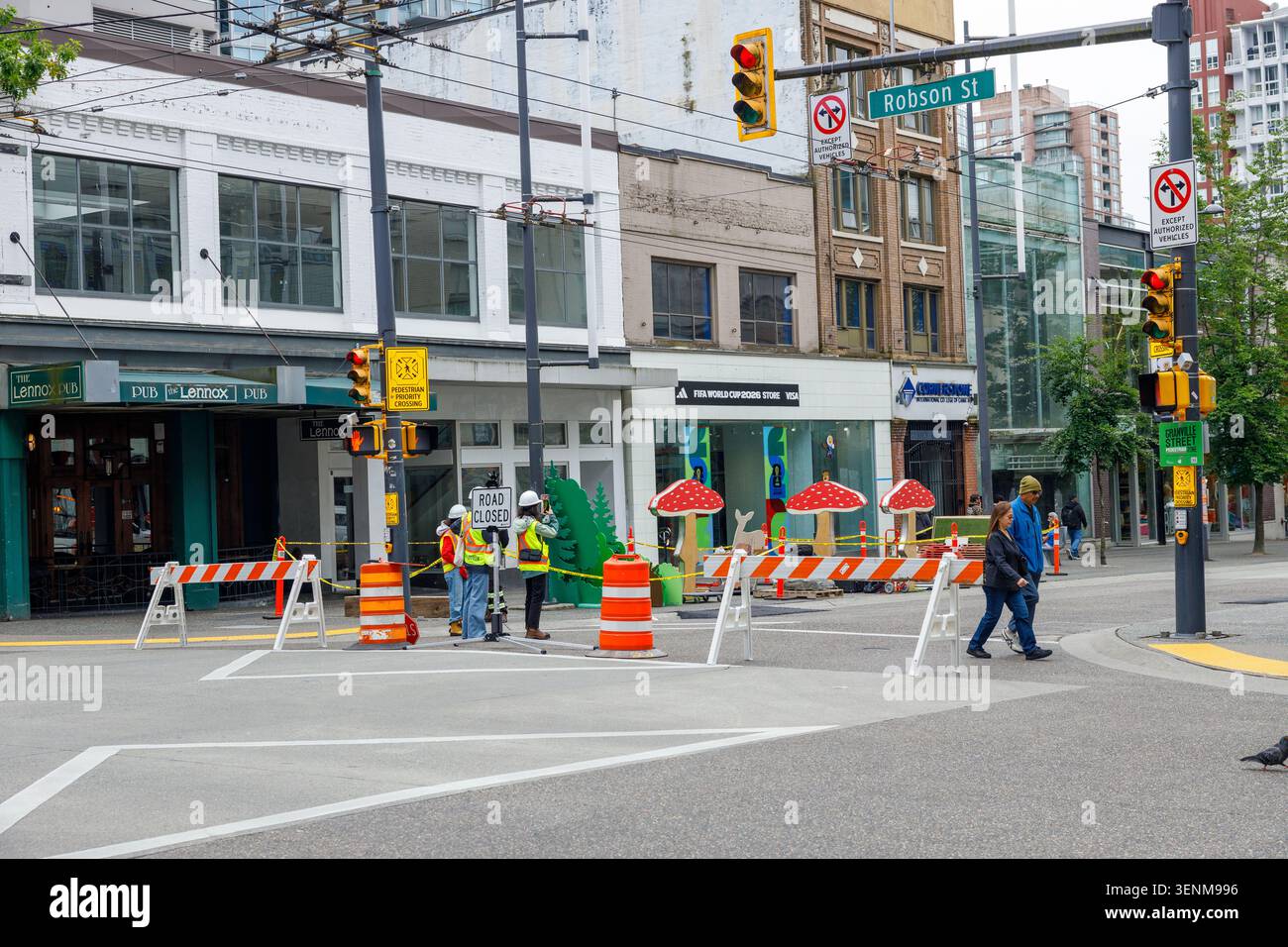 Vancouver, Kanada - 8. Juni 2026: Arbeiter in gut sichtbaren Westen errichteten für die FIFA World C eine geschlossene Barriere in der Robson Street und der Granville Street in der Innenstadt Stockfoto