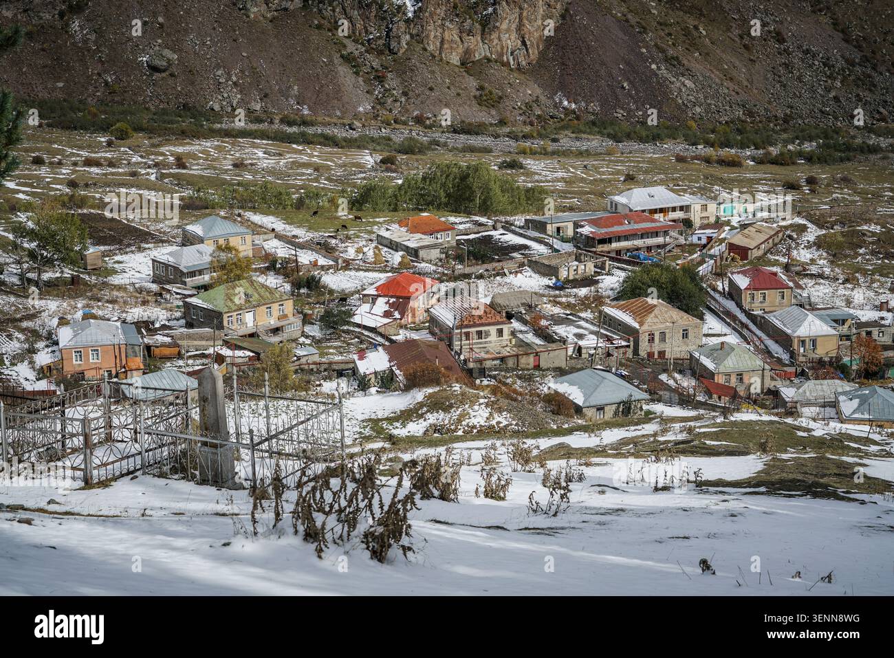 Ein Blick aus der Vogelperspektive zeigt das malerische Dorf Stepantsminda, Georgia, mit seinen vielen Häusern mit farbenfrohen Dächern, die mit Schnee im frühen Winter bedeckt sind. Stockfoto