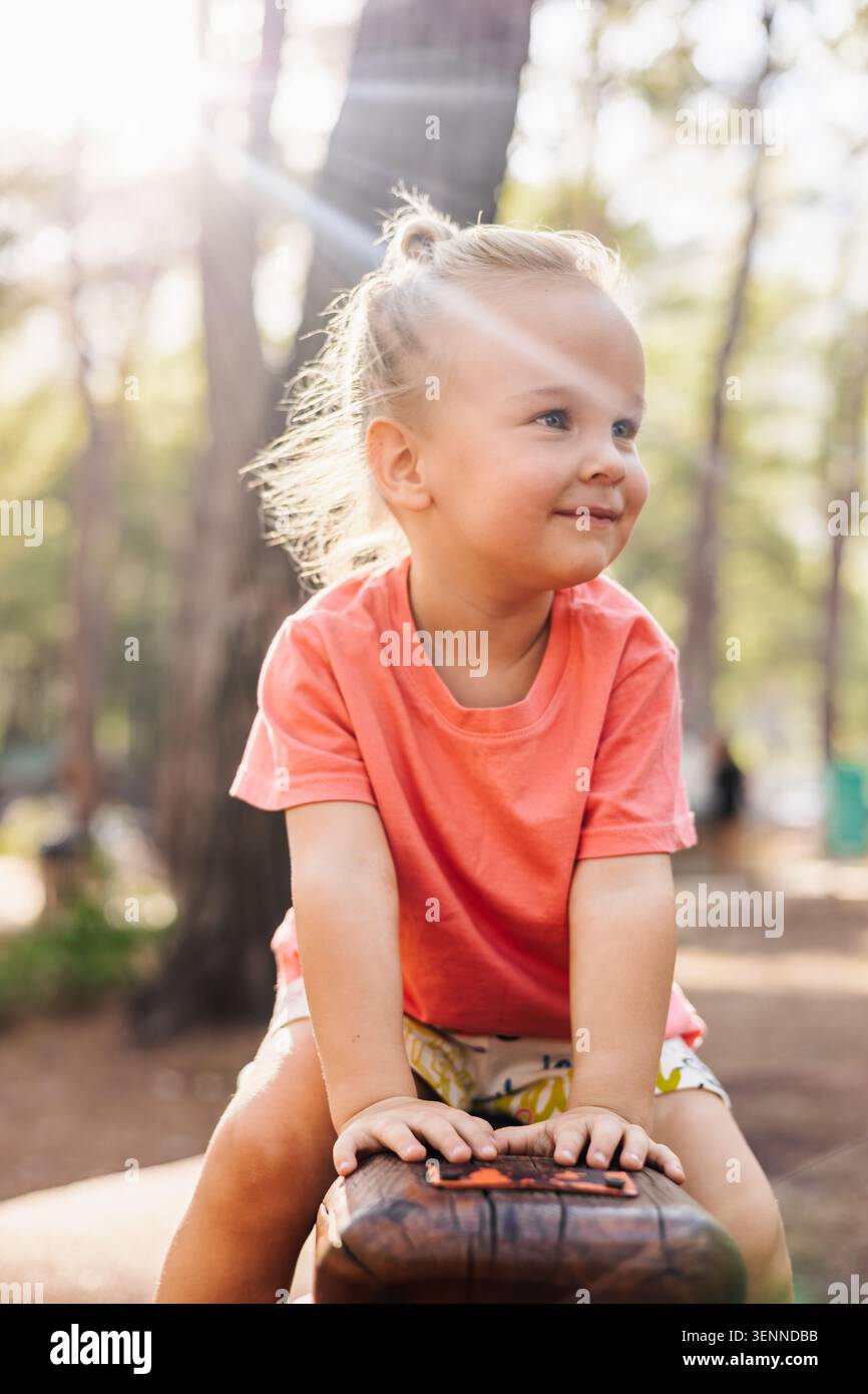 Niedliches Kleinkind mit blonden Haaren, das draußen lächelt Stockfoto
