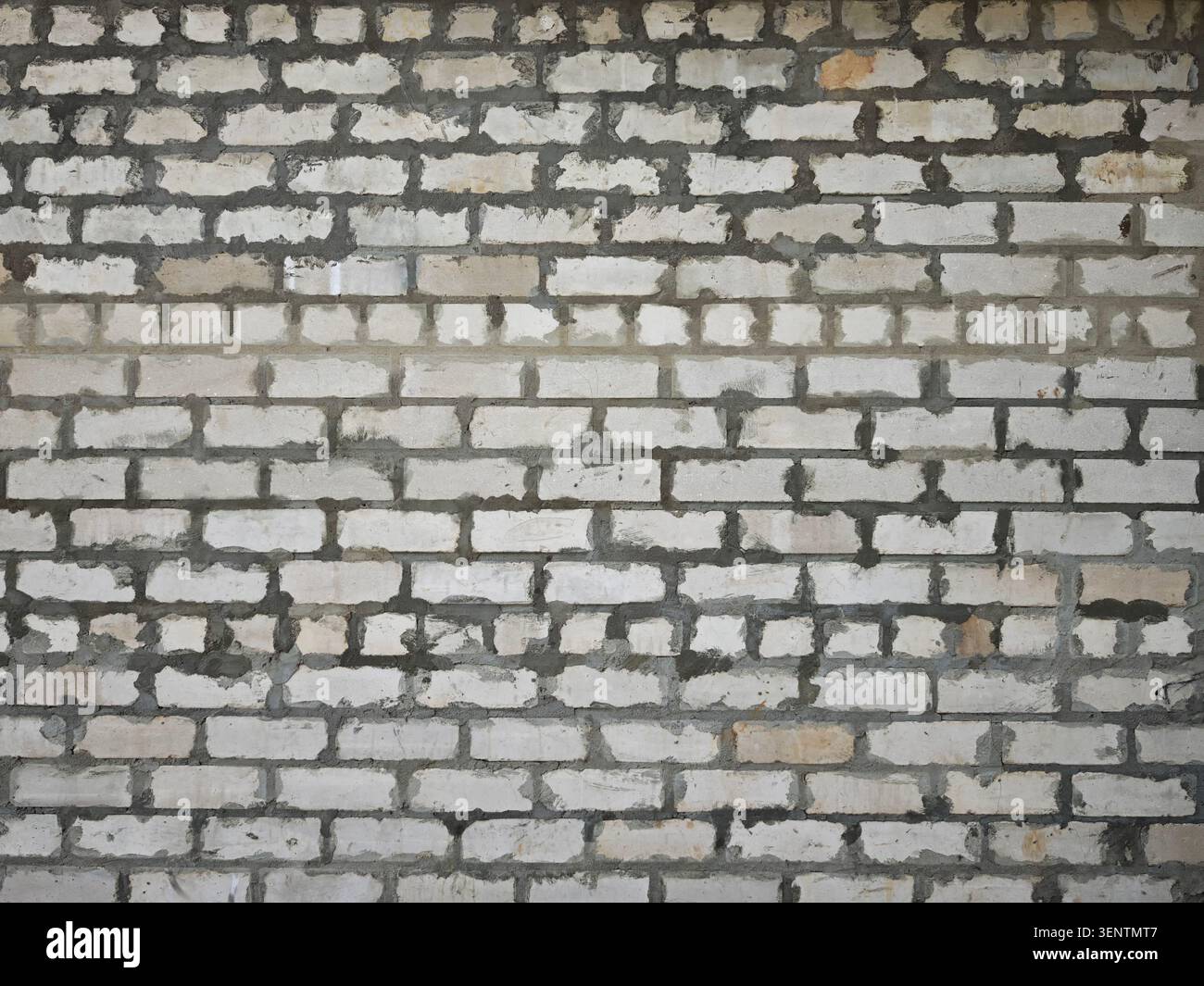 Ansicht einer rauen Ziegelwand mit auffälligen Mörtelfugen, geeignet für den Einsatz in verschiedenen Konstruktionsprojekten oder als Hintergrund. Stockfoto