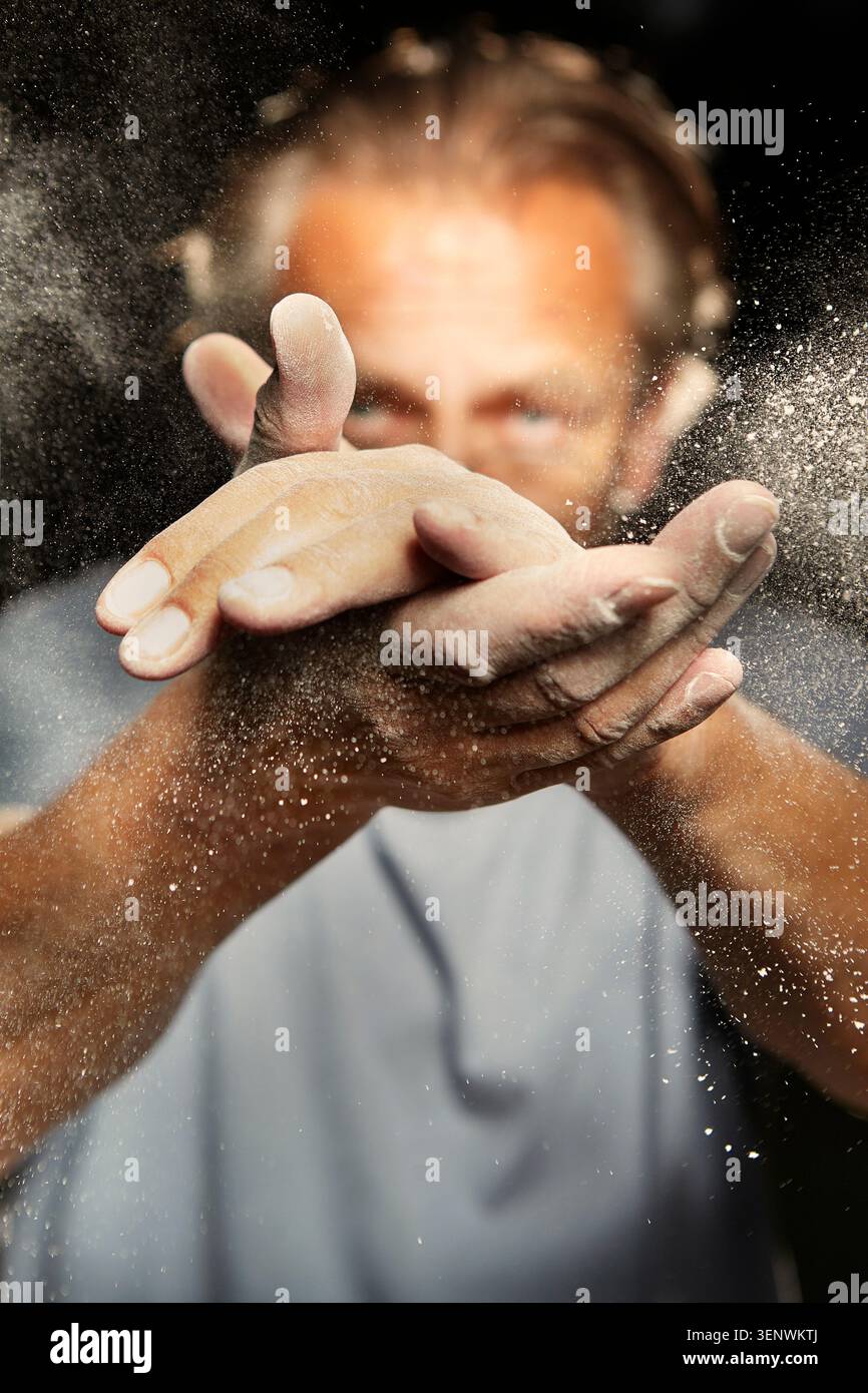 Mann klatscht mit seinen schmutzigen Händen, um Staub und Schmutz von der Haut zu entfernen Stockfoto