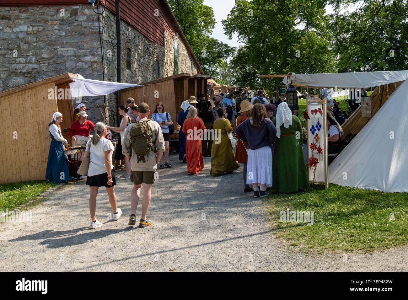 Juni 2025: Besucher und Händler von mittelalterlich inspirierter Kleidung treffen sich während des jährlichen Mittelalterfestes in Hamar, Norwegen, an Marktständen Stockfoto