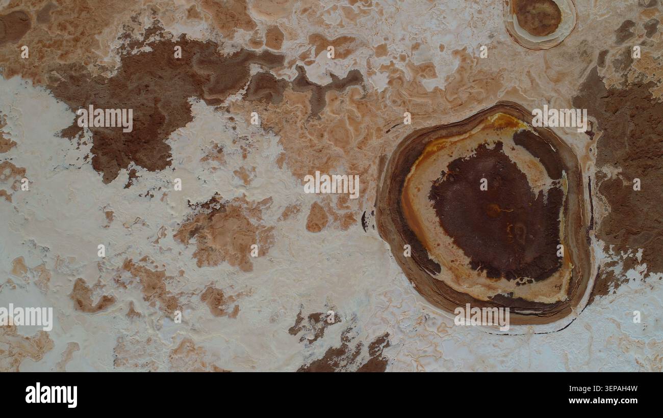 Geradliniger Blick auf einen natürlichen Heißwasserteich, der von komplexen Salzkrusten und geothermischen Mineralringen in der Danakil-Depression umgeben ist Stockfoto