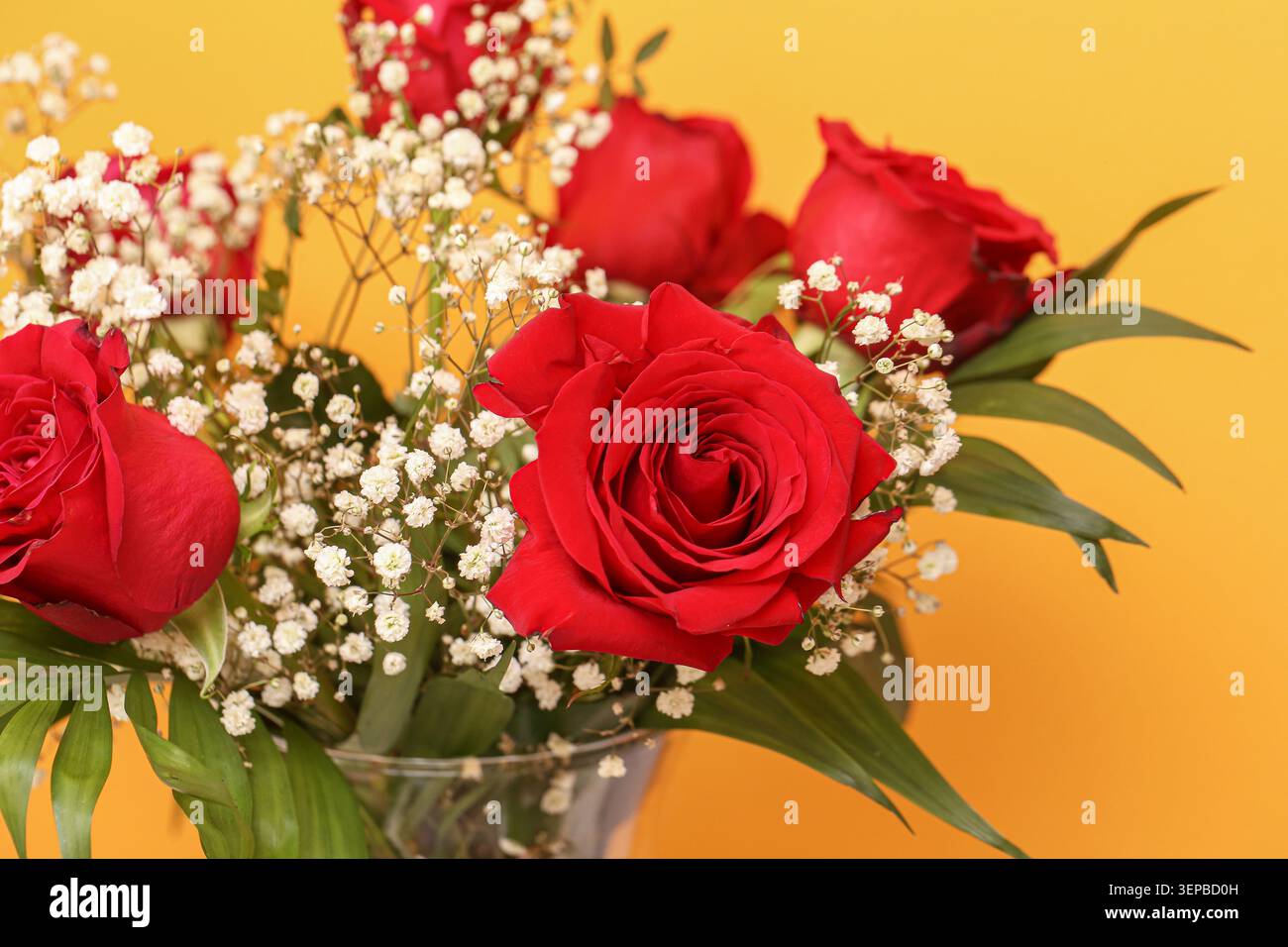 Rote Rosen-Blumenstrauß mit dekorativen Blumen auf hellem Hintergrund. Blumengeschenke für romantische und besondere Anlässe. Stockfoto