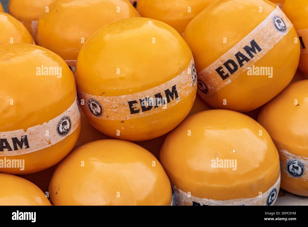 Edam, Niederlande - 31. Mai 2026 - Nahaufnahme der traditionellen runden gelben Edam-Käseräder, die auf einem niederländischen Markt zusammengestapelt sind. Stockfoto