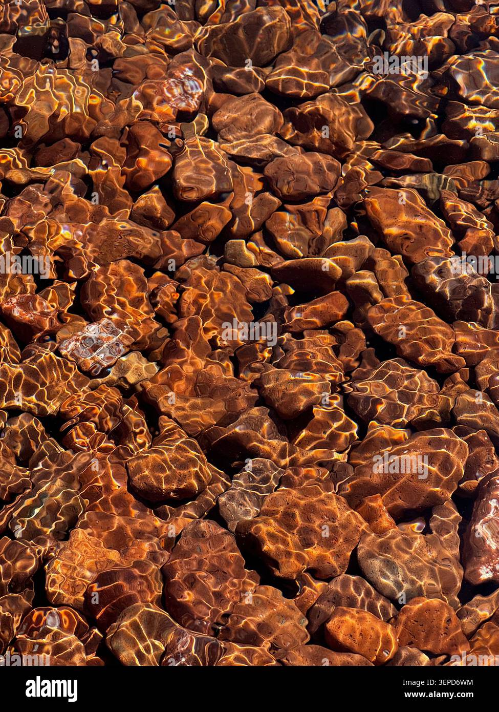 Kristallklares Wasser des Sees mit felsigem Ufer darunter Stockfoto