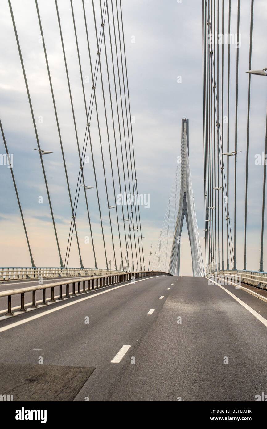 Eine Nahaufnahme der leeren Asphaltstraße auf der Normandie Bridge. Die Seiten der Fahrbahn werden von den dichten vertikalen Linien von s dominiert Stockfoto