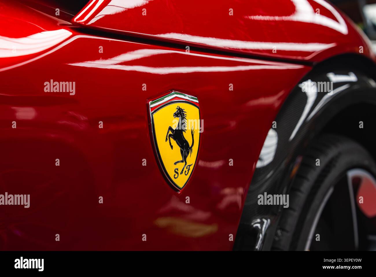 Ferrari Scuderia-Schild auf glänzendem Karosserieblech mit Radlauf aus Carbon Stockfoto