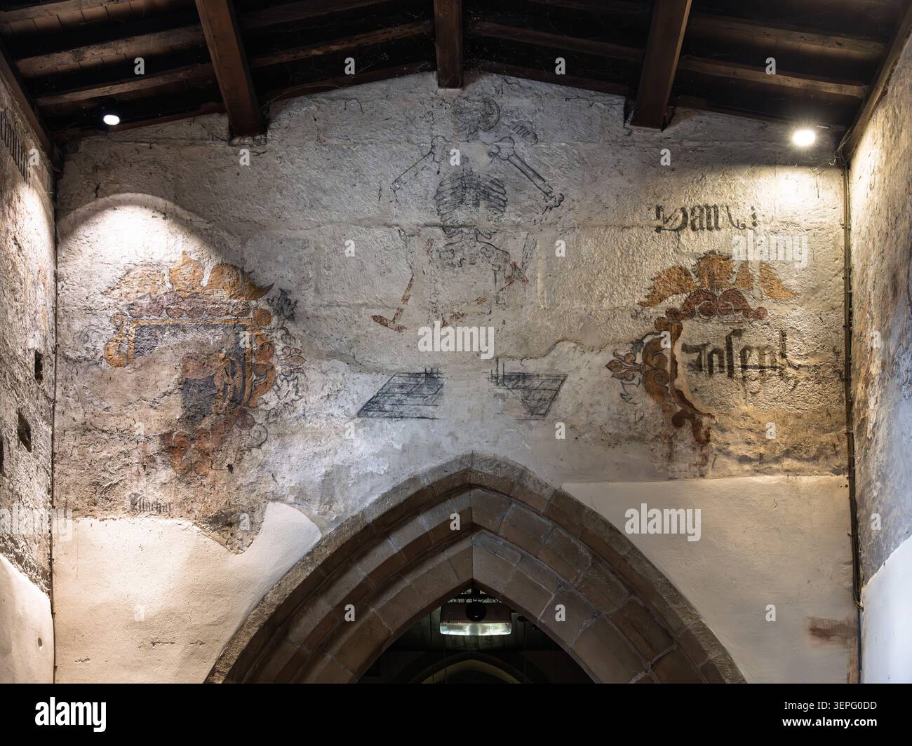 Detaillierter Blick auf die verblassten mittelalterlichen Wandmalereien und den Steinbogen im historischen Heiligtum der St. Lawrence Church in Eyam Stockfoto