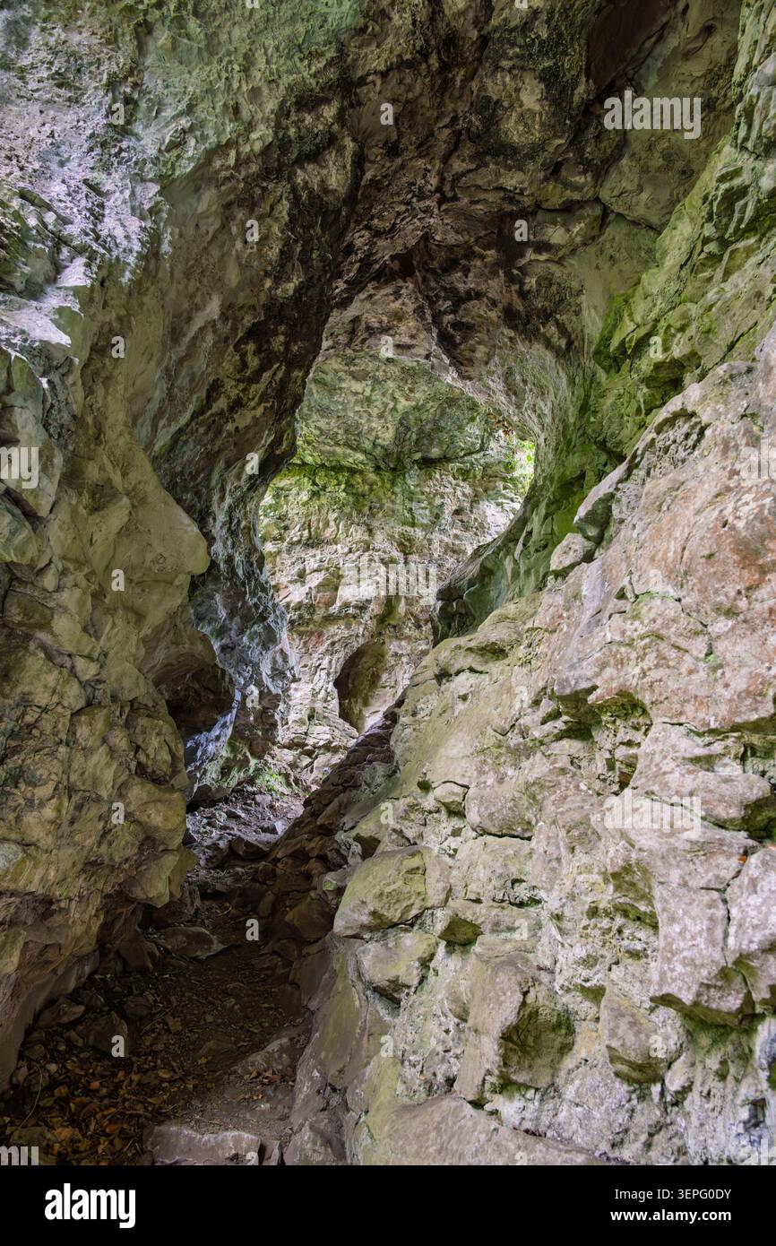 Blick durch die natürliche Kalksteinfelsenbogenformation, bekannt als Cucklet Church, im bewaldeten Delph-Tal bei Eyam Stockfoto