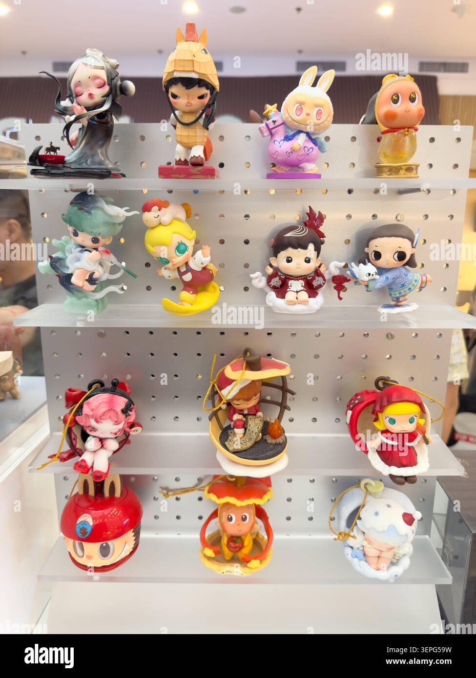 Ein mehrstufiges Regal in einem Pop Mart Store in Cebu City zeigt eine große Auswahl an stilvollen Designerfiguren auf individuellen transparenten Stafeln Stockfoto