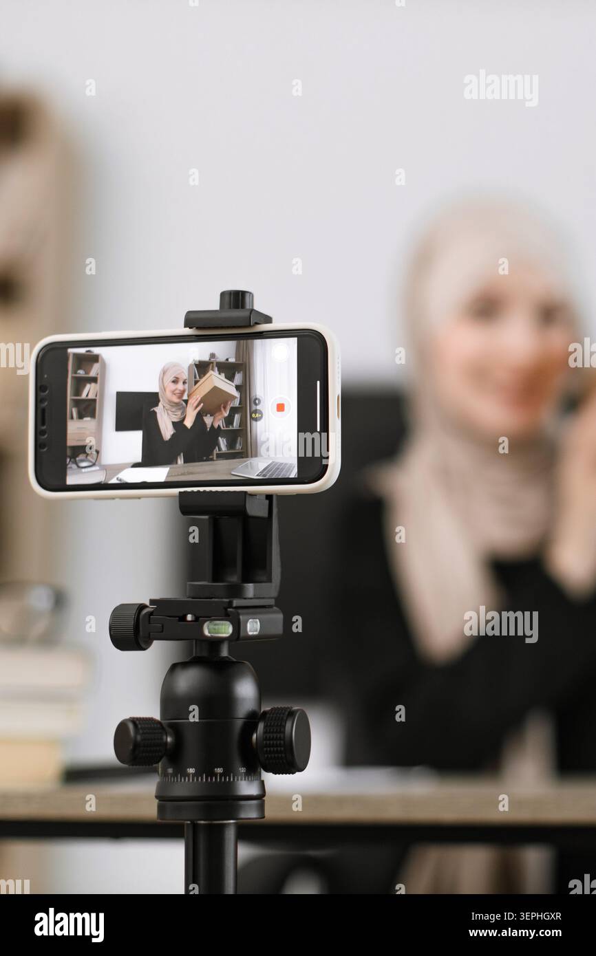 Frau filmt Buchrezension am Telefon Stockfoto