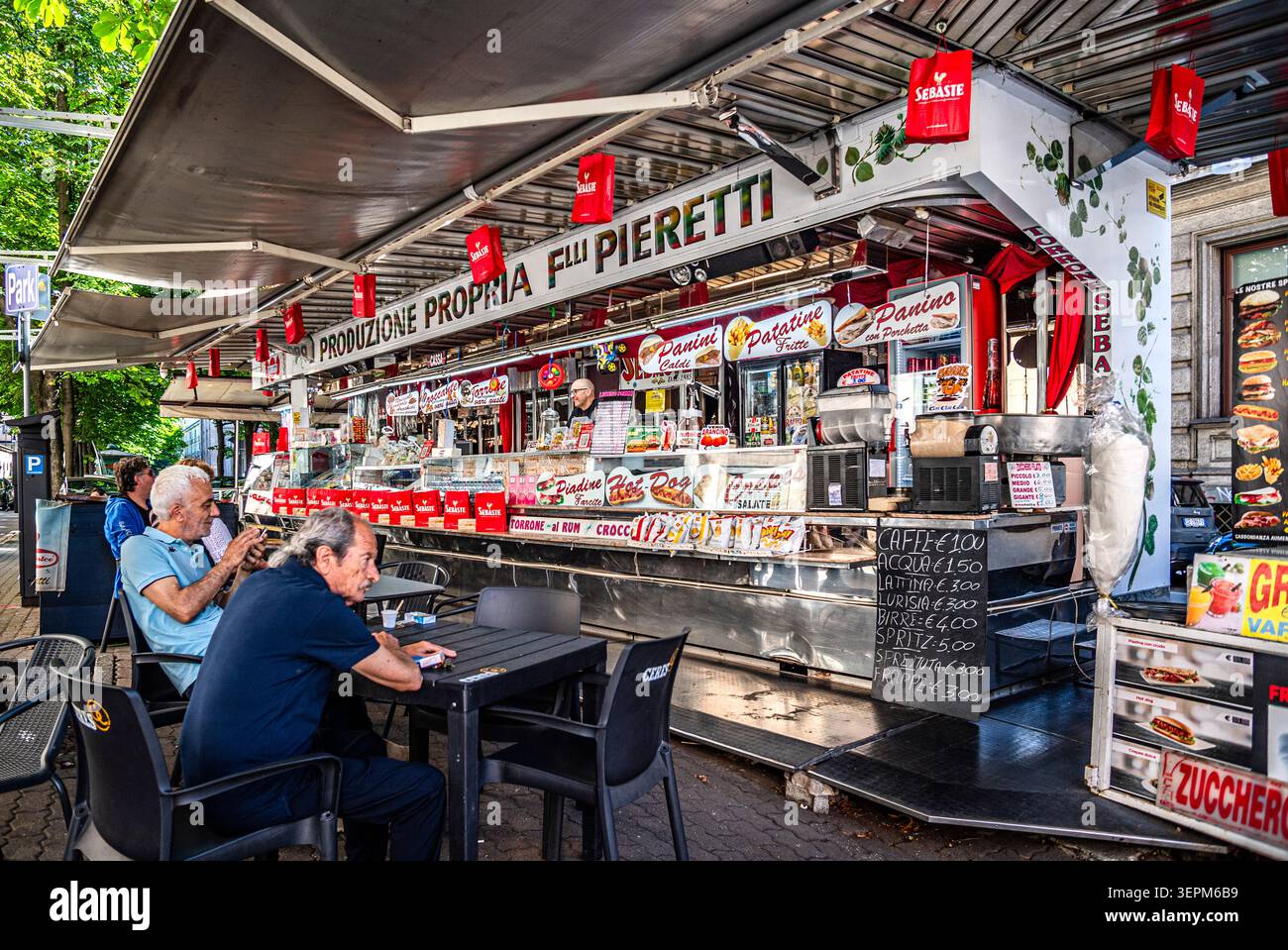 Street-Food-Kiosk an der Via Garibaldi in Turin, Piemont, Italien, wo die Leute an Tischen im Freien sitzen und Snacks und Getränke im Schatten der Bäume genießen. Foto von Toni Spagone. Stockfoto
