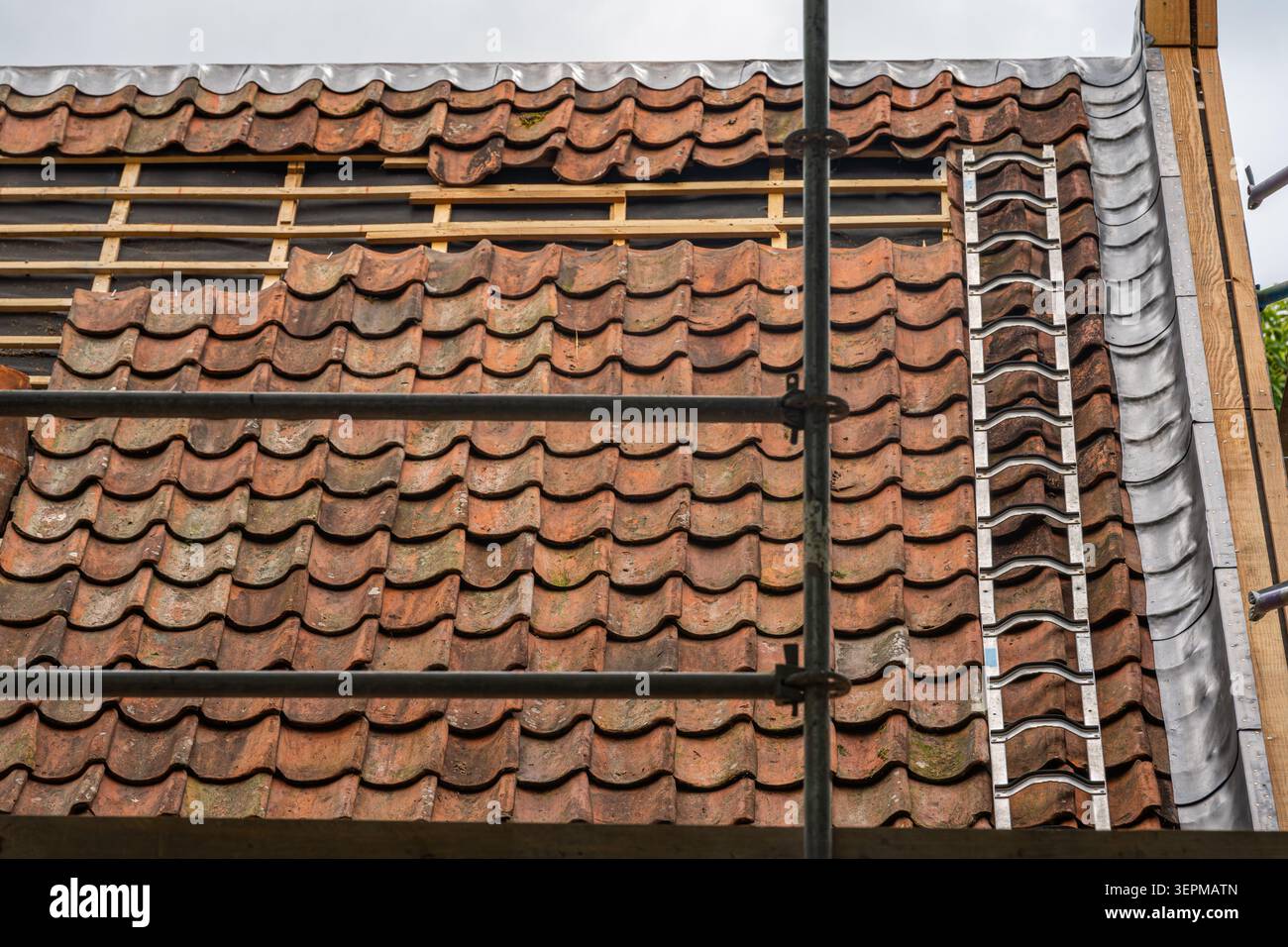 Reparatur und Austausch von Lehmbachziegeln am alten Haus während der Dachsanierung Stockfoto