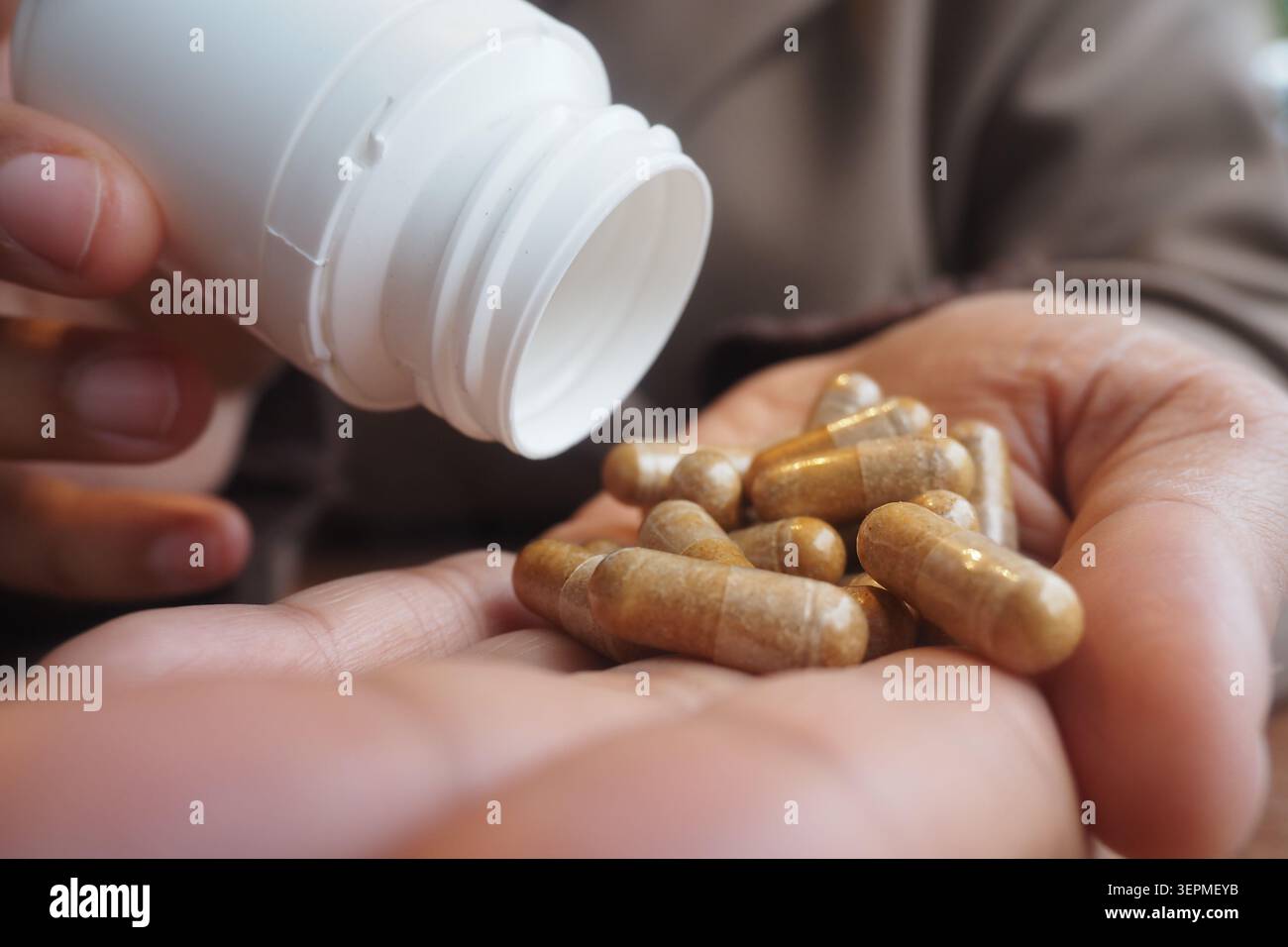 Kapseln aus einer Flasche in die Hand einer Person gießen Stockfoto