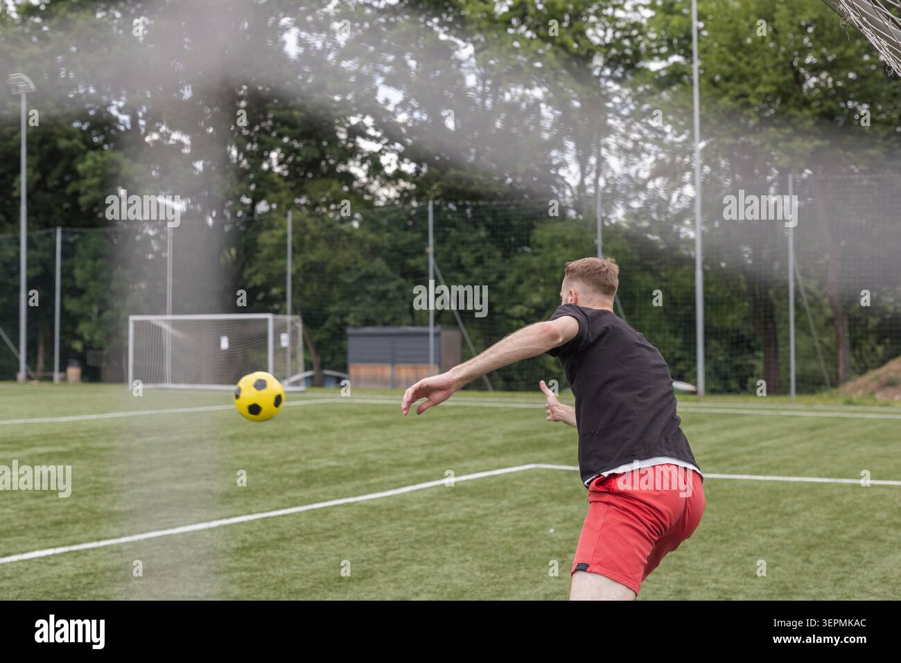 Ein Torhüter trainiert auf einem Fußballfeld, während er Verteidigung übt. In dieser Session geht es um die Entwicklung von Fähigkeiten. Stockfoto