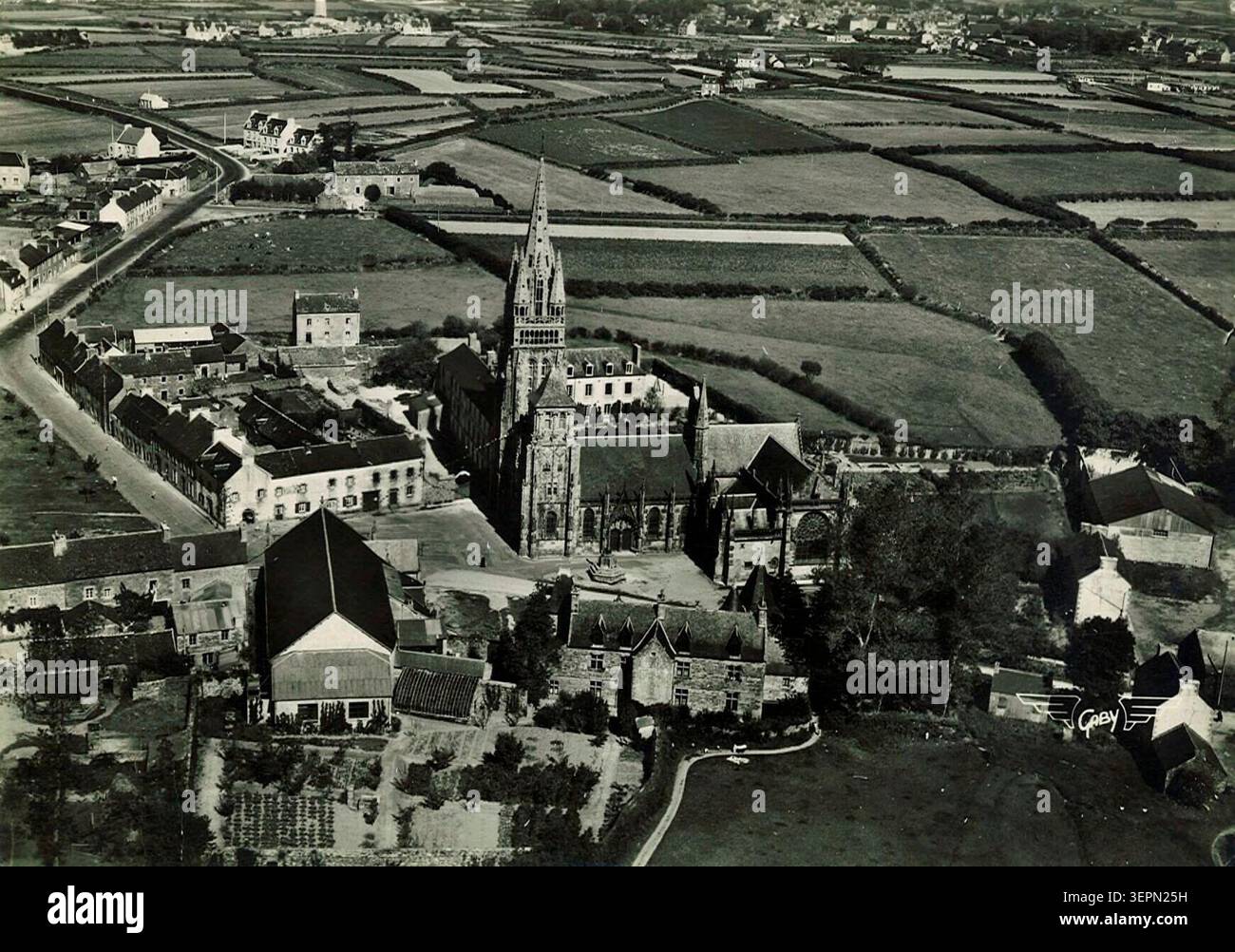 Die Basilika Le Folgoët präsentiert eine extravagante gotische Architektur, in der die 1419 geweihte Kirche Notre-Dame in einem strukturierten religiösen Setting steht, das durch Steindetails und Kalvarienelemente gekennzeichnet ist und ein bedeutendes Wahrzeichen der Finistère-Devotionalität bildet Stockfoto