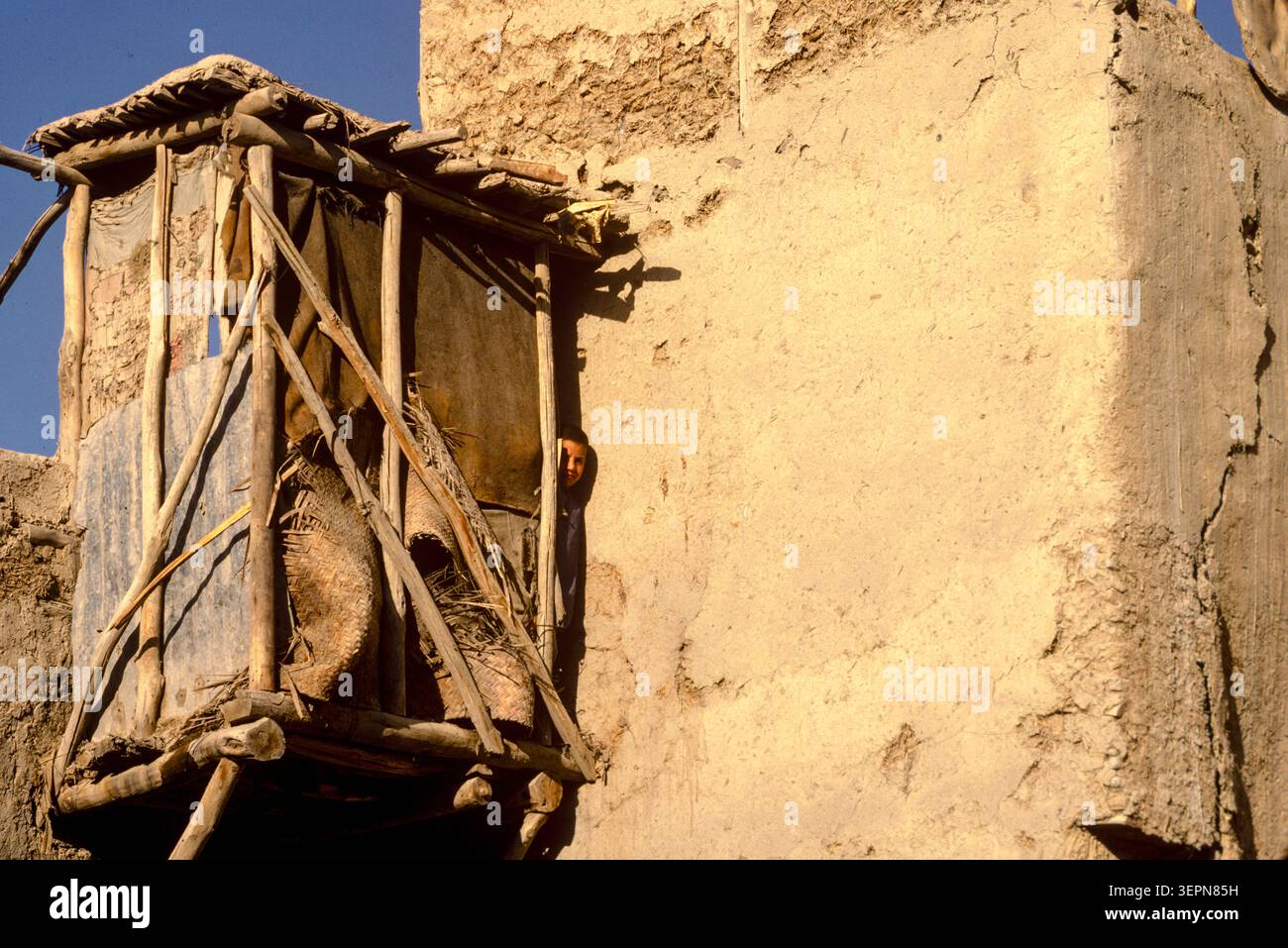 Ein Kind wächst an der Seite einer Taditioanl-Toilette in der Altstadt von Kabul, Afghanistan, 1992 Stockfoto