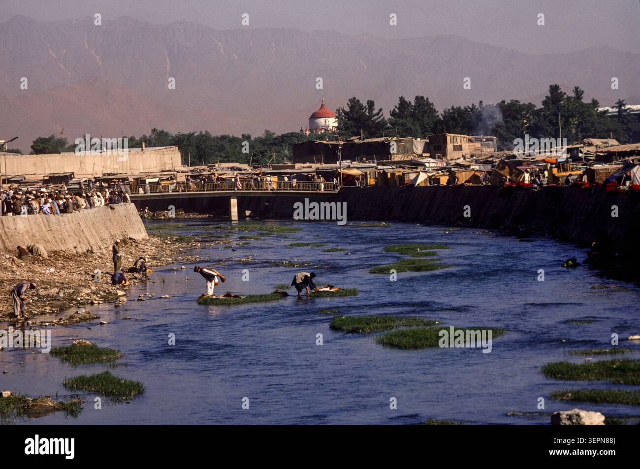 Bürstenverkäufer waschen ihre Bürsten im Fluss Kabul neben dem geschäftigen Marktgebiet, Kabul Afghanistan, August 1992 Stockfoto