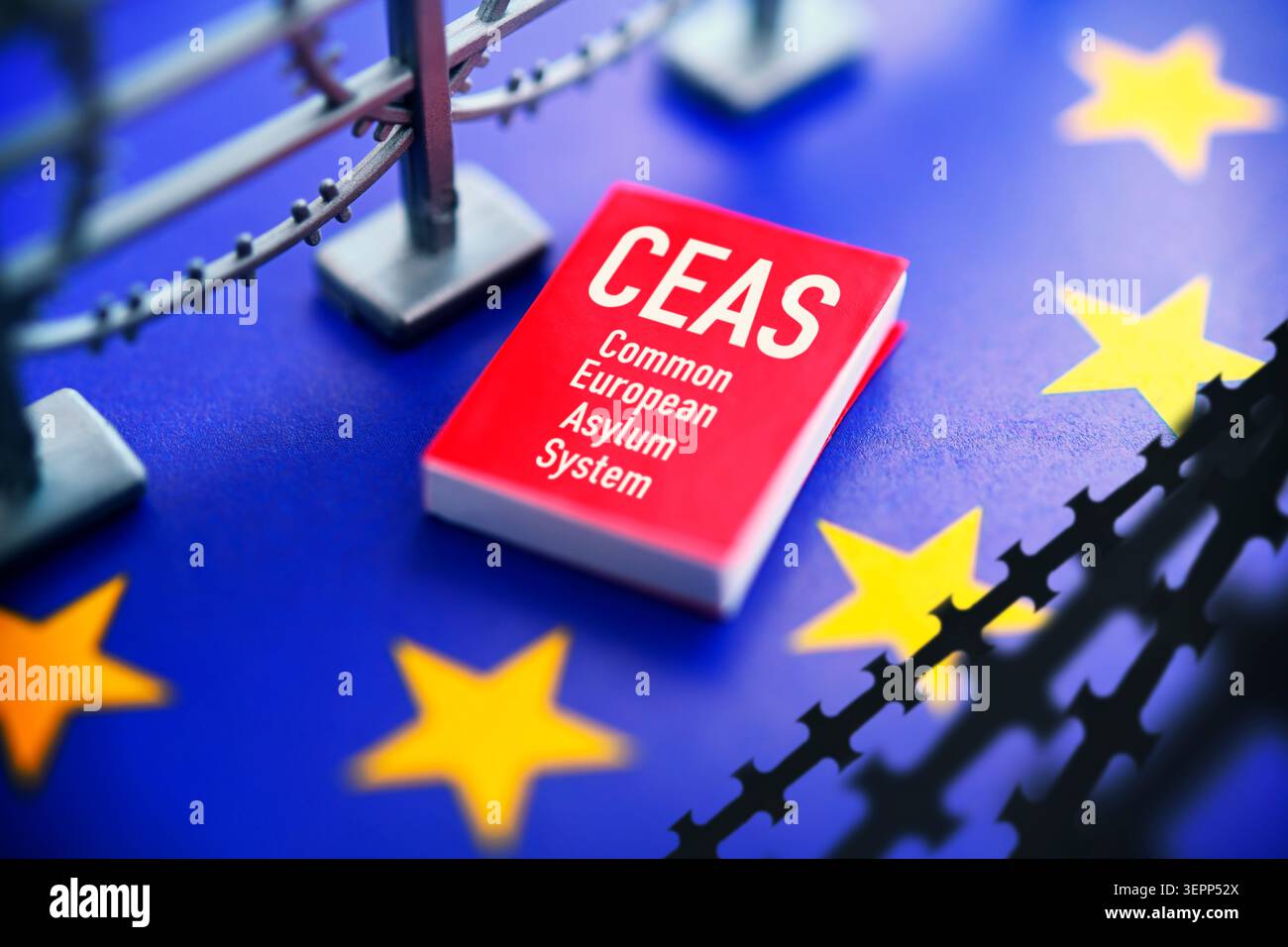 Buch mit CEAS-Schriftzug auf EU-Flagge mit Stacheldraht, europäische Asylreform, Fotomontage Stockfoto