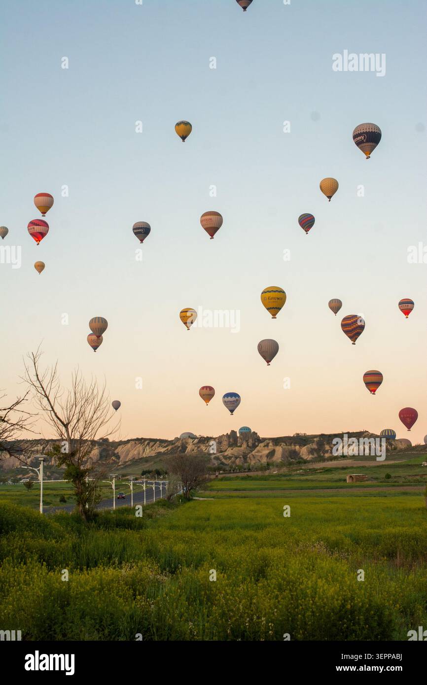 Malerische Aussicht auf farbenfrohe Heißluftballons, die über die einzigartige Landschaft Kappadokiens, Türkei, fliegen. Stockfoto