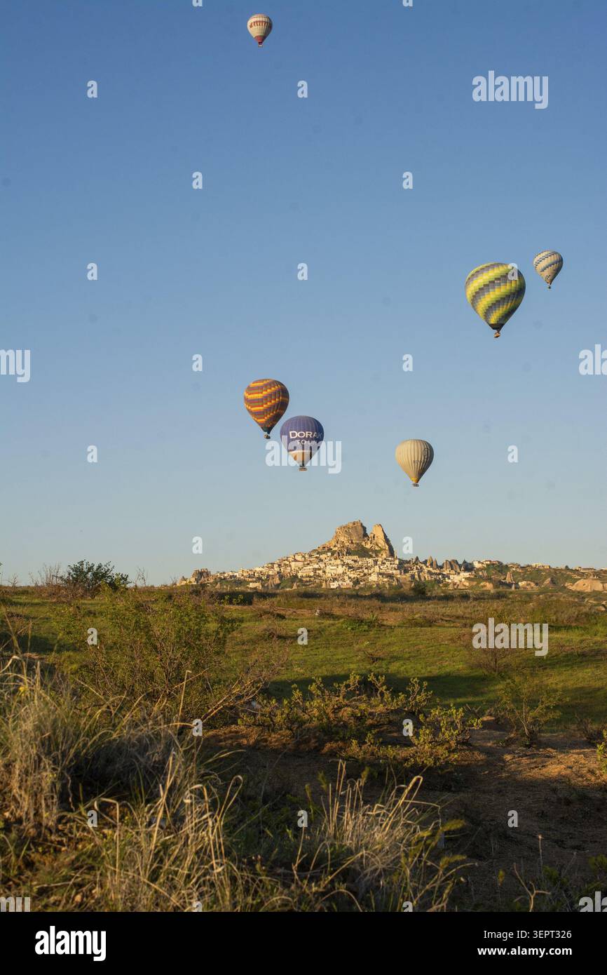 Malerische Aussicht auf farbenfrohe Heißluftballons, die über die einzigartige Landschaft Kappadokiens, Türkei, fliegen Stockfoto