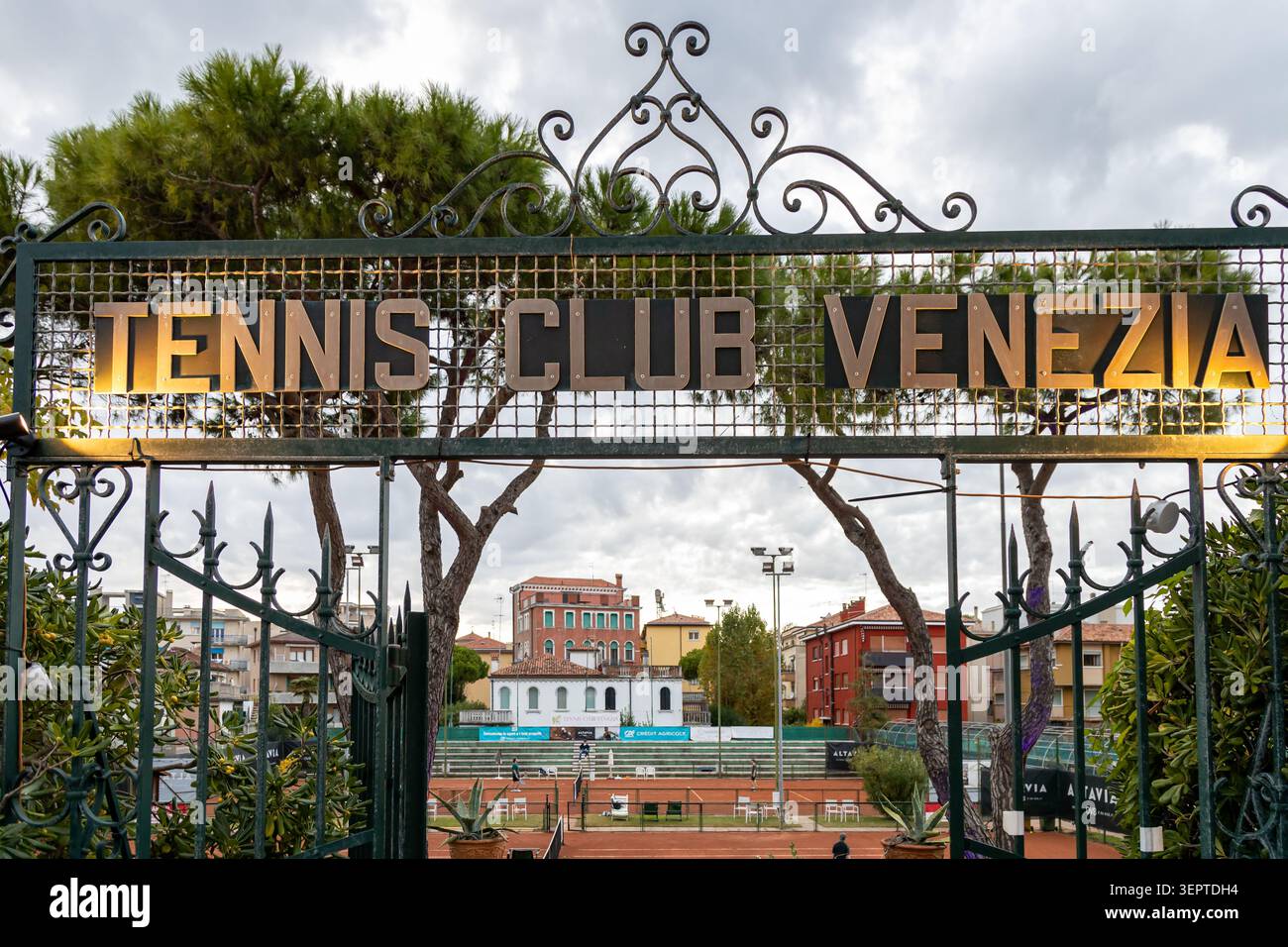 Lido di Venezia, Venedig, Italien - 25. Oktober 2025: Das kunstvoll verzierte, eiserne Eingangstor des Tennisclubs Venezia mit Lehmplätzen im Hintergrund Stockfoto
