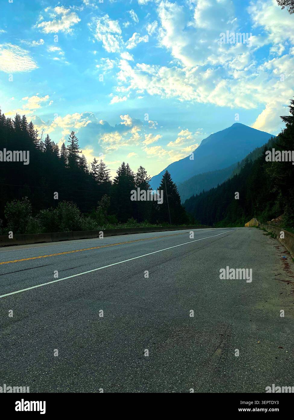 Die malerische Bergstraße schlängelt sich durch üppige grüne Wälder, umgeben von atemberaubenden Landschaften, frischer Luft und der Schönheit unberührter Natur. - Smartphone-aufgenommenes Stockfoto