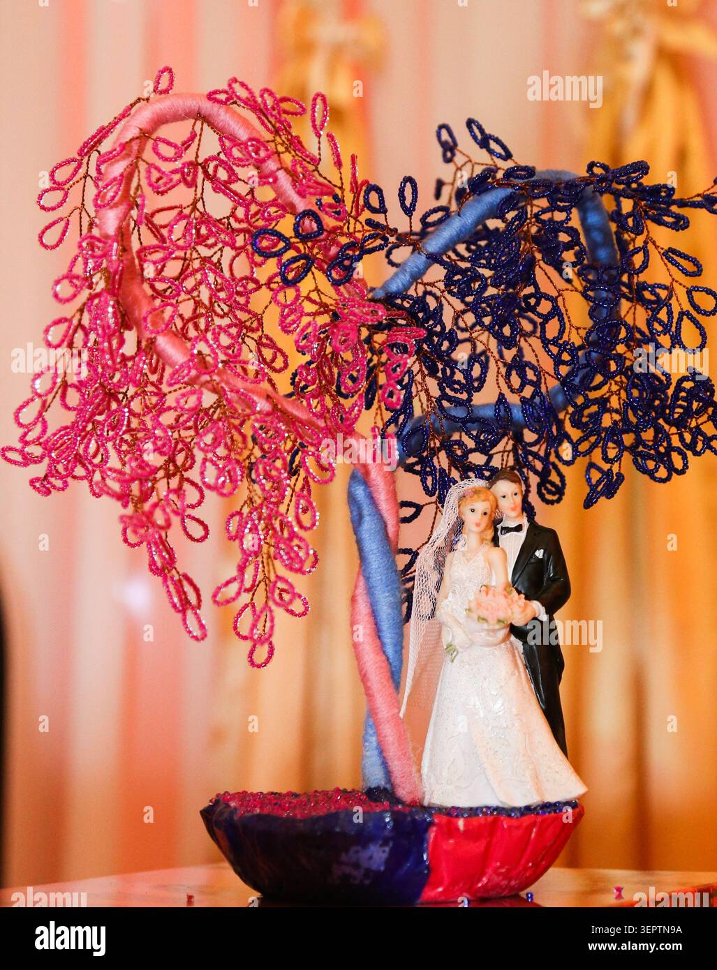 Die Figur eines Paares steht darunter und umschließt sich zärtlich. Hochzeitstorte, symbolisiert Liebe und lebenslanges Engagement. Ideal für romantische und feierliche Zwecke Stockfoto