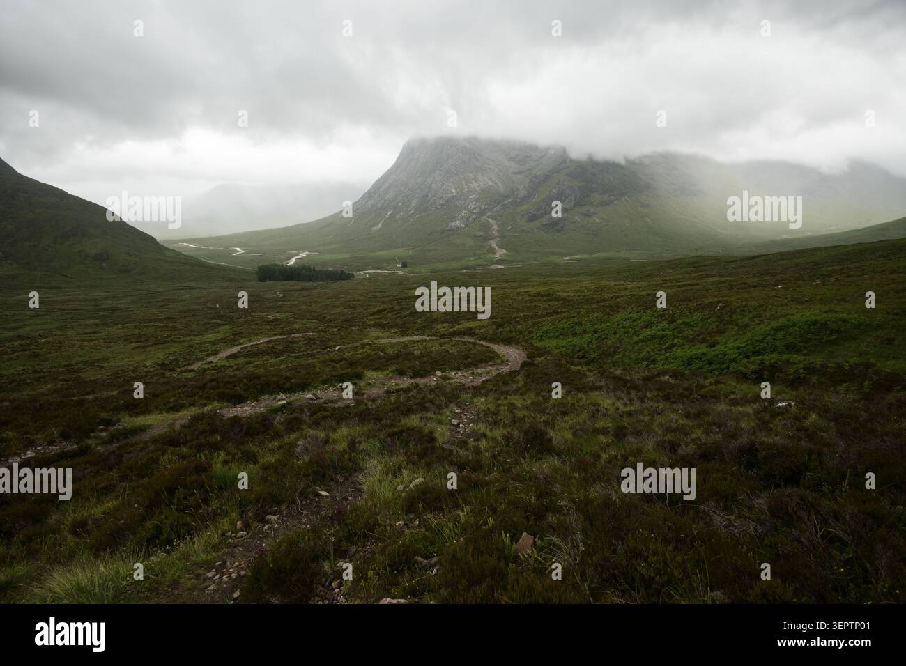 Kurviger Pfad über Moorland in Richtung Stob Dearg und Lagangarbh Hütte unter dramatischem bewölktem Himmel, Glencoe, Scottish Highlands, Stockfoto