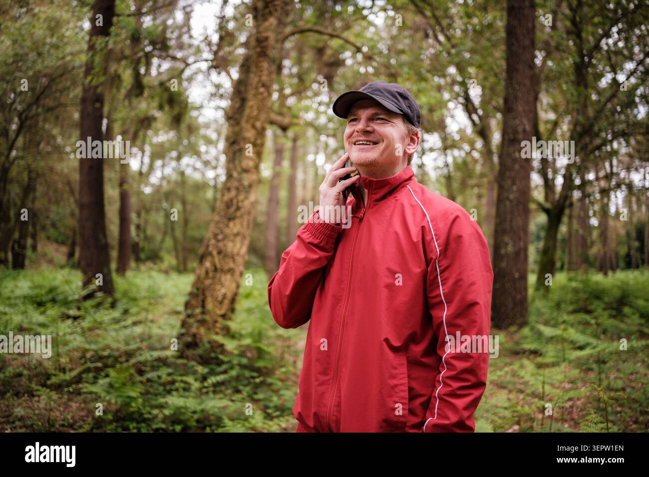Mann, der am Telefon spricht, Kommunikation und Natur genießt Stockfoto