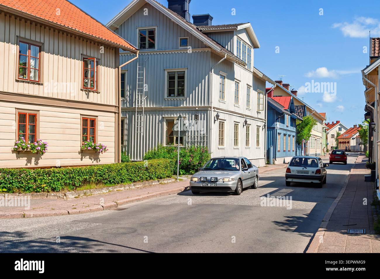 Charmante skandinavische Wohnstraße mit Autos an einem sonnigen Sommertag Stockfoto