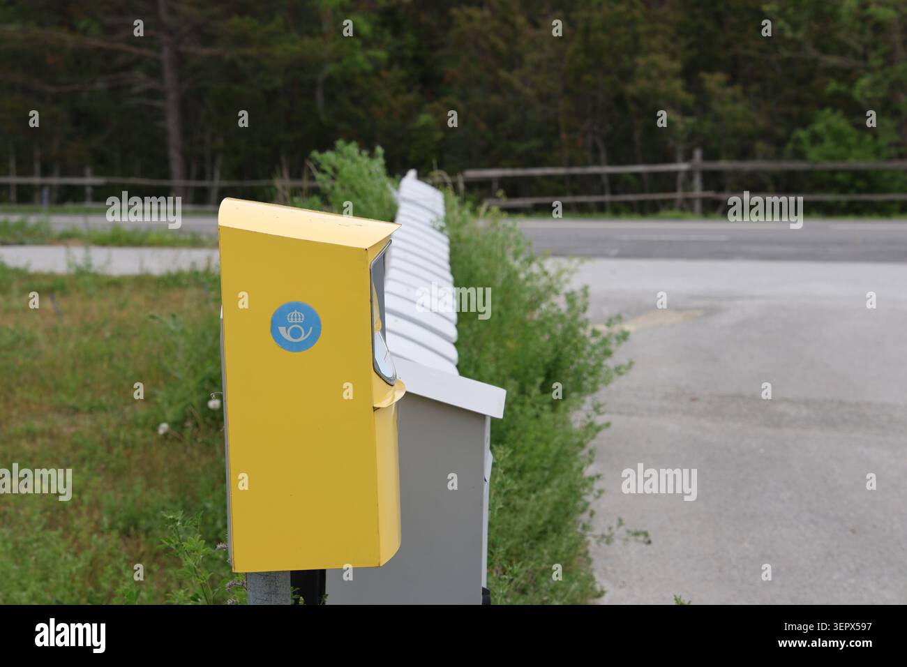 Reihe schwedischer Postfächer in ländlicher Umgebung, die den lokalen Postdienst in Schweden repräsentieren. Stockfoto