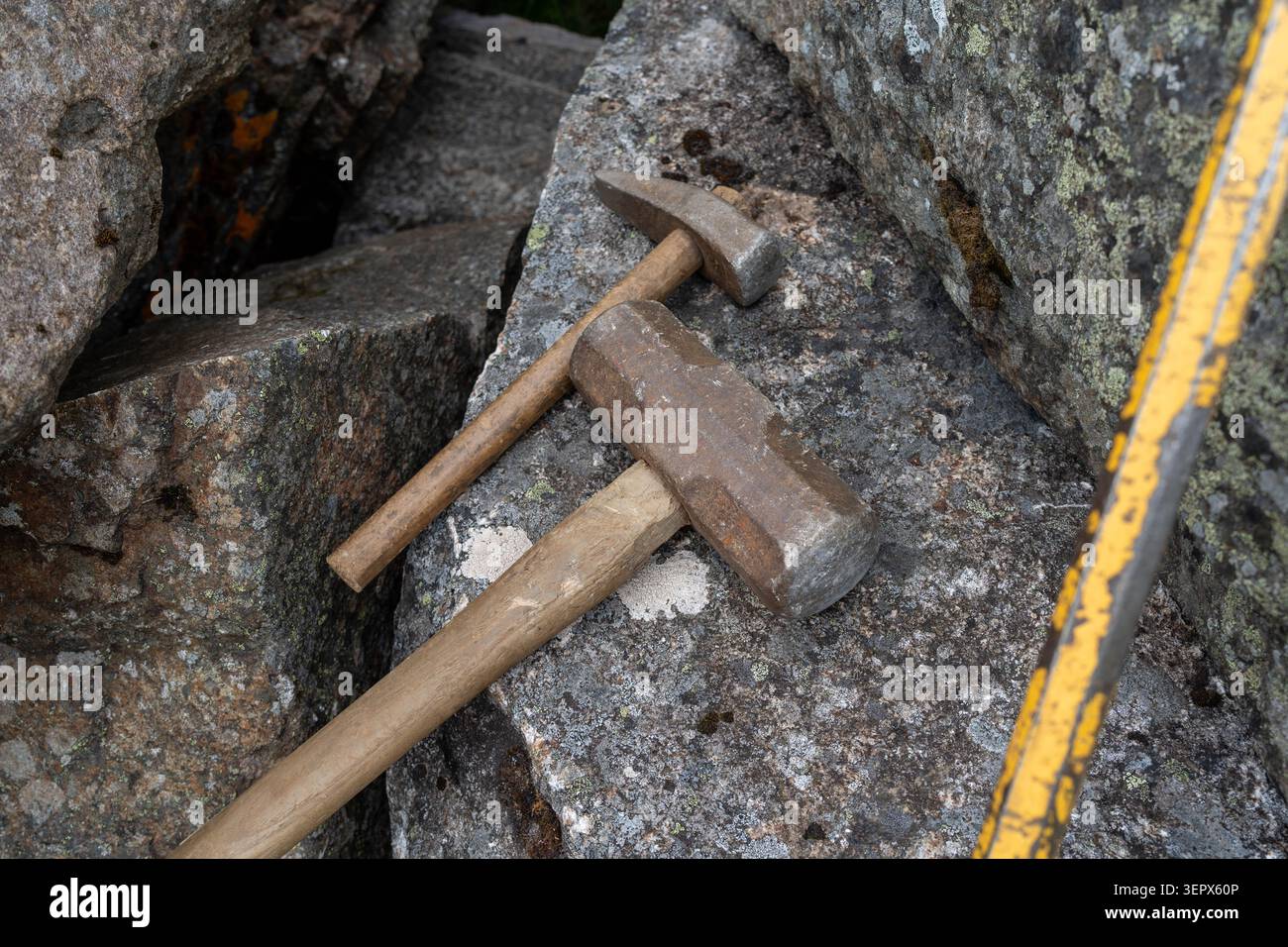 Geologische Hämmer auf freiliegendem Felsvorkommen während Feldarbeit Stockfoto